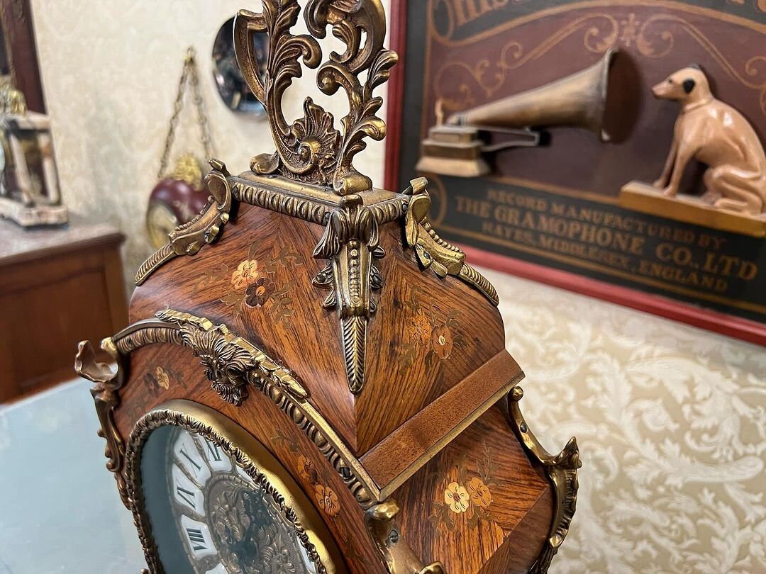 Antique French 1890s marquetry fireplace clock with intricate wood inlay and ornate design, displayed in a vintage setting.