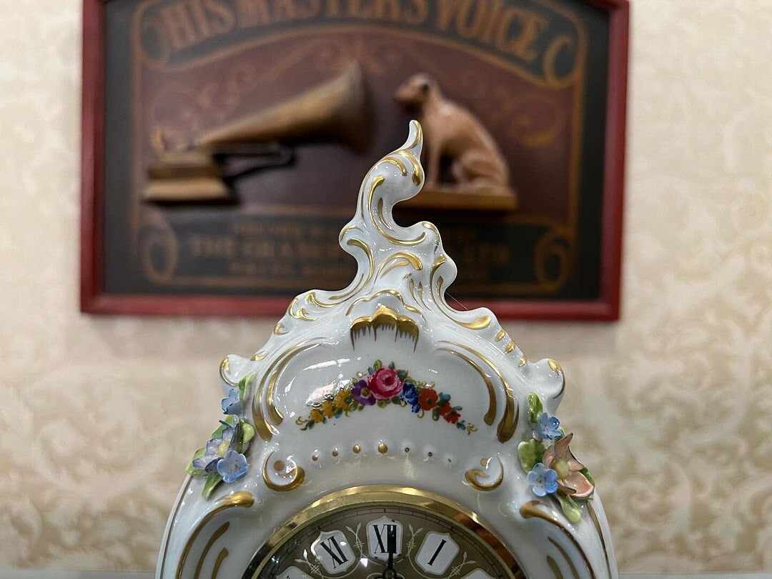 Antique Capodimonte Porcelain Quartz Clock with floral design in front of vintage gramophone sign
