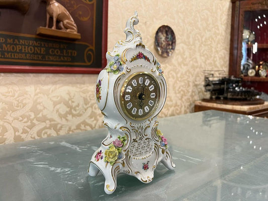 Antique Capodimonte porcelain quartz clock in immaculate condition (front view) displayed in an elegant room.