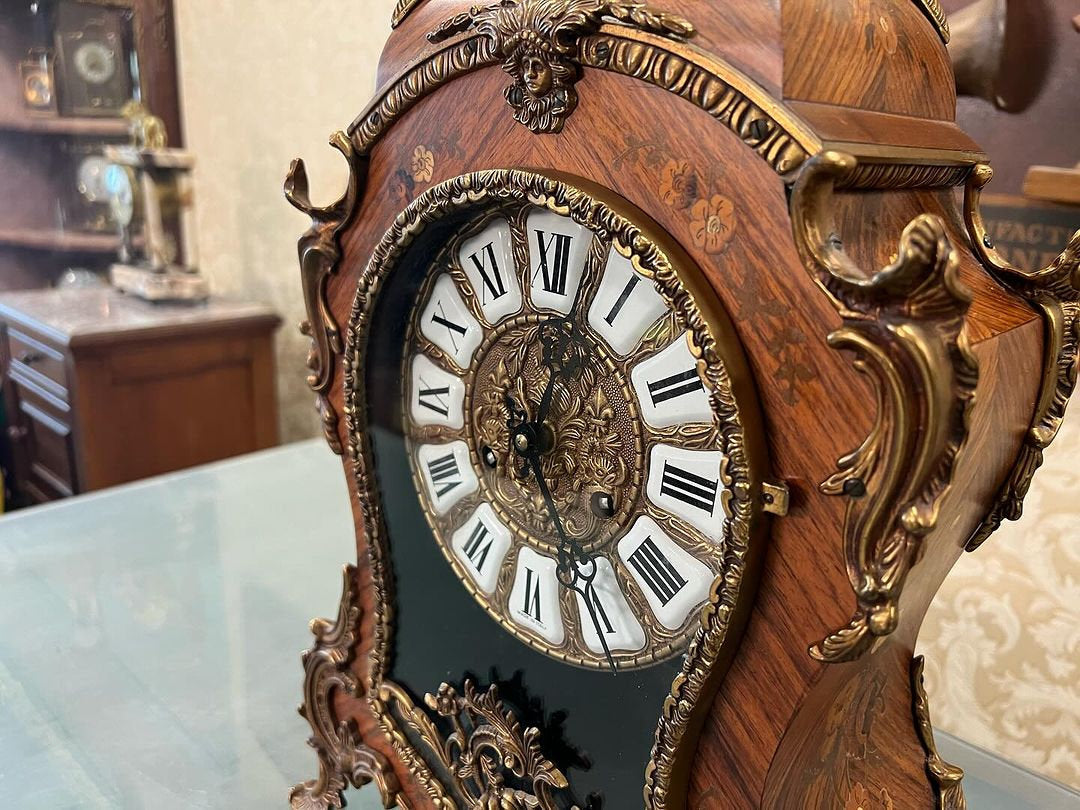 Antique French 1890s marquetry fireplace clock with intricate wood inlay and Roman numerals on display