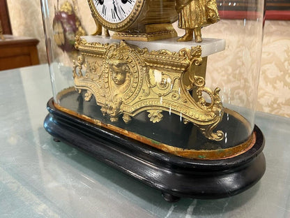 Antique French 1890s glass-domed marquetry fireplace clock with intricate gold detailing, showcased on a marble base.