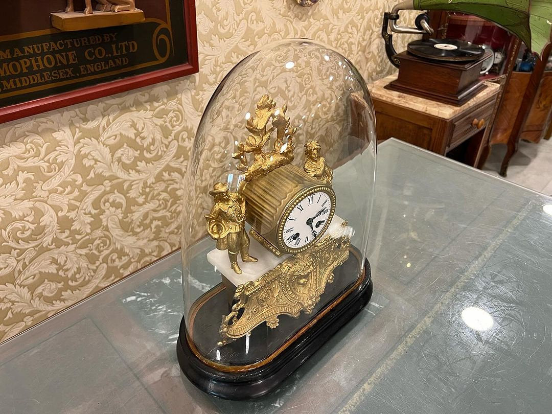 Antique French 1890s glass-domed marquetry fireplace clock in perfect condition displayed on a glass table.